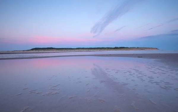 スウェーデンの海岸線の水で満たされた砂の多い地域の素晴らしい夕日 雲は水に反射しています — ストック写真