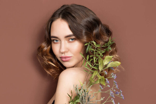 portrait of a beautiful young woman with flowers. Tenderness and aroma. wavy hair and shine