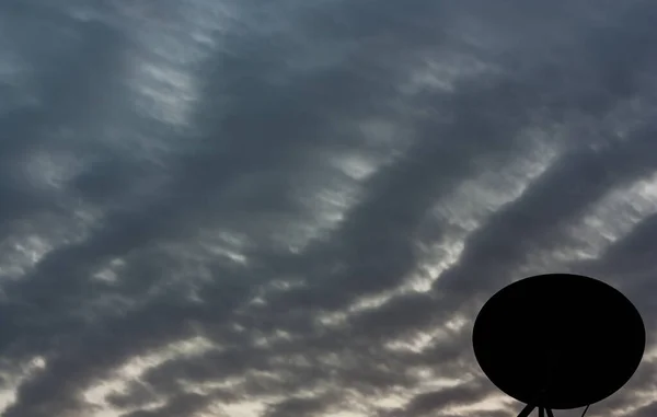 Renkli bir gökyüzü olan siluet uydu anteni