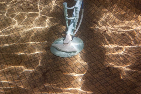 Подводное фото автоматического чистильщика бассейна на полу бассейна — стоковое фото