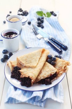 yakın plan krep ve yaban mersini tabağı.