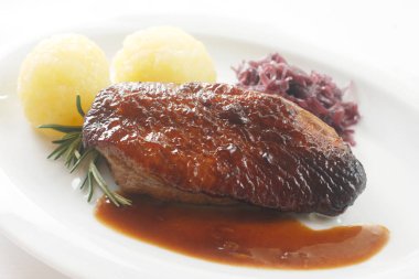 Beyaz arka planda yakın plan biftek ve patates.