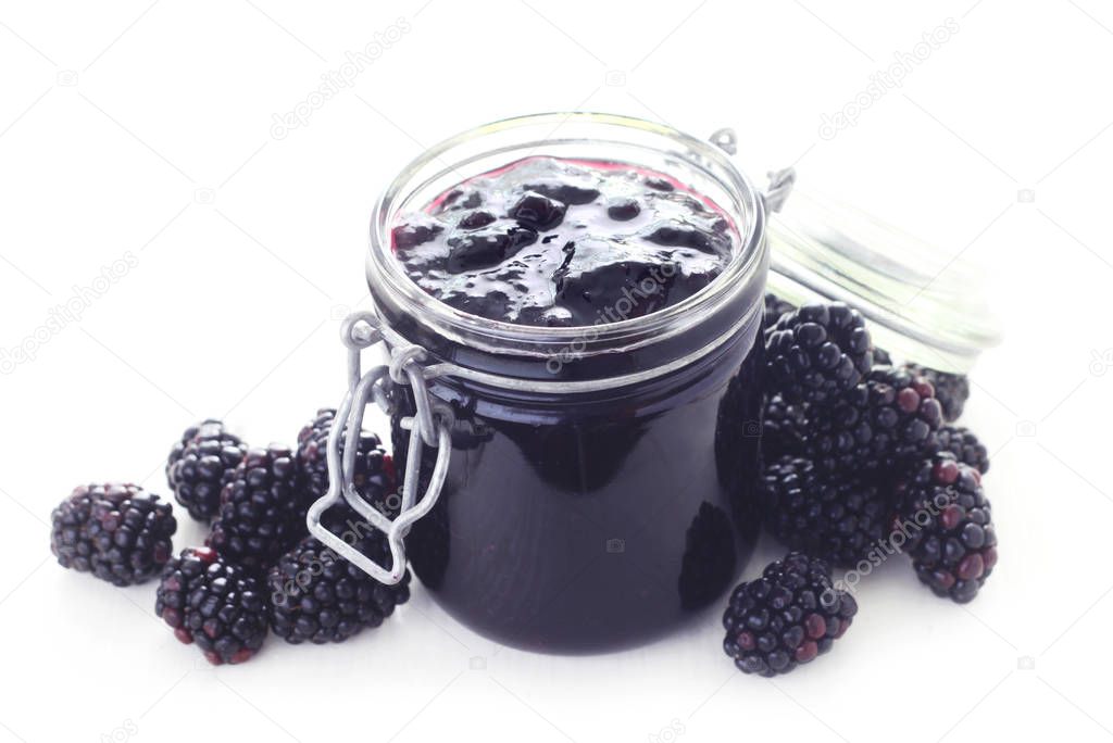 close-up shot of blackberries jam in mason jar on white background