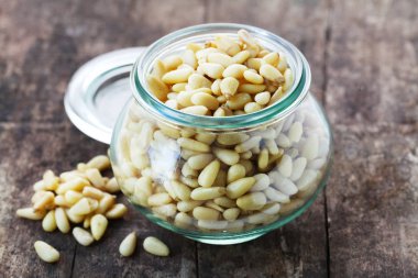 Tahta bir arka planda kavanozda çam fıstığı