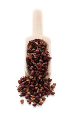 Tahta küreğin üzerindeki Szechuan biberi beyaza izole edilmiş.