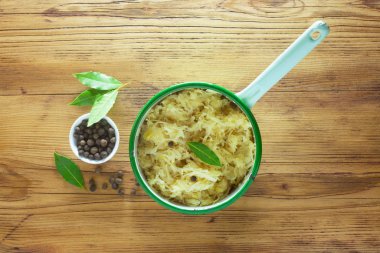 Yeşil bir tencerede içindeki malzemelerle lahana turşusu