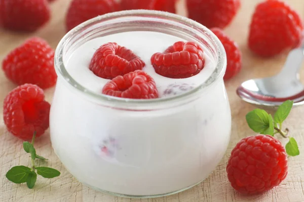 A Glass Of Plain Yogurt With Raspberries