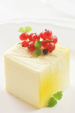 Beyaz arkaplanda kırmızı frenk üzümü ve cheesecake 'in yakın plan çekimi.