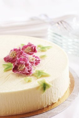 Beyaz arka planda çiçekli cheesecake 'in yakın plan çekimi.