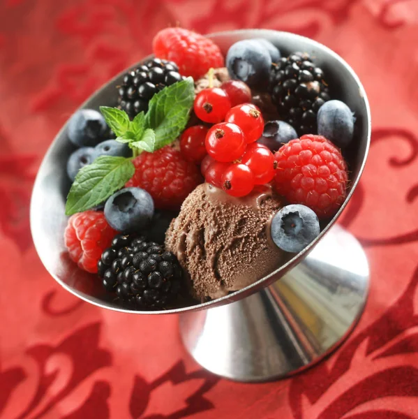 Chocolate Ice Cream Dessert with Mixed Berries on a Red Background