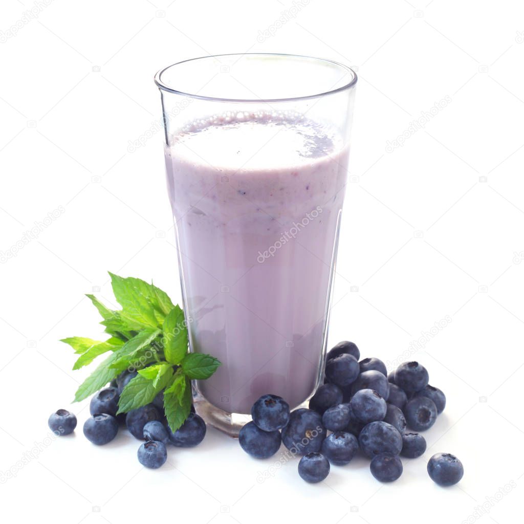 glass of milkshake and blueberries isolated on white