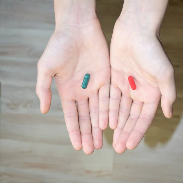 赤と青の錠剤を保持ライト背景に少年の手は 選択肢を提供します 選択的焦点 — ストック写真