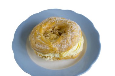 Süt kremalı ve mavi tabakta pudra şekerli poğaça halkaları. Beyaz bir arkaplanda izole edilmiş.