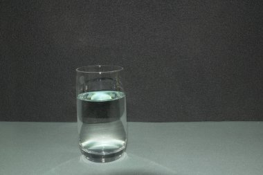 Mavi ve siyah zemin üzerinde su olan cam. Koyu kopya alanı