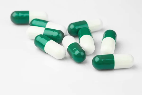 stock image Pharmacy theme.Green capsules and white antibiotic pills.