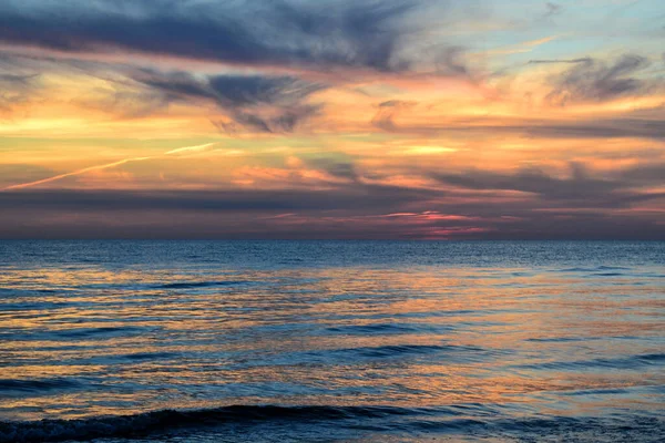Mar Báltico. Colorido atardecer al final del día con nubes reflejadas en el agua . — Foto de Stock