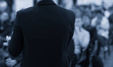 Konferans salonunda ya da seminer toplantısında, iş ve eğitim kavramında seyirciye dik bir bakış açısıyla sahnede. Sözcü iş toplantısında bir konuşma yapacak. Seminer sunum fotoğrafı.