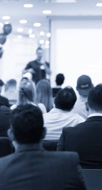 Kurumsal konferansta seminer sunucusu konuşma yapıyor. Konuşmacı iş izleyicilerine ders veriyor. Şirket eğitimi etkinliği sırasında salonda tartışma yürüten yönetici. 