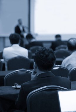 Kurumsal konferansta seminer sunucusu konuşma yapıyor. Konuşmacı iş izleyicilerine ders veriyor. Şirket eğitimi etkinliği sırasında salonda tartışma yürüten yönetici. 