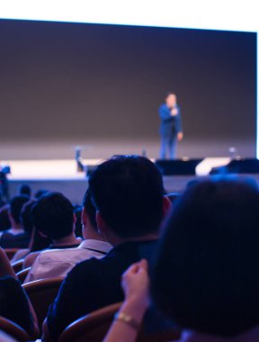 Sözcü bir şirket iş konferansında konuşma yapıyor. Seyirciler sunucu önünde sunucuyla salonda. Şirket yöneticisi iş ve girişimci semineri sırasında konuşma yapıyor.