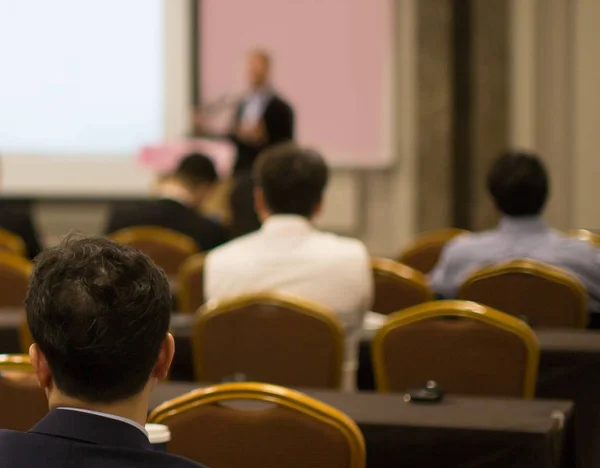 Business presentation being given by tech executive. Corporate seminar with expert speaker presenting to people. Man giving speech during lecture. Leadership training coach in workshop.