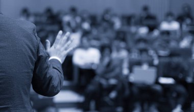 Sözcü bir şirket iş konferansında konuşma yapıyor. Seyirciler sunucu önünde sunucuyla salonda. Şirket yöneticisi iş ve girişimci semineri sırasında konuşma yapıyor.
