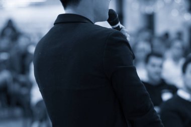 Sözcü bir şirket iş konferansında konuşma yapıyor. Seyirciler sunucu önünde sunucuyla salonda. Şirket yöneticisi iş ve girişimci semineri sırasında konuşma yapıyor.