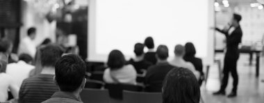 Profesyonel konuşmacı tarafından şirket konferansında konuşma yapılacak. Yönetici yönetici, girişimciler için liderlik atölyesinde izleyicilere sunum yapıyor. İş eğitimi alan insanlar.