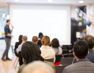 Salonda dinleyicilere sunum yapan uzman konuşmacı ile seminer. Kopyalama alanı için boş iş sunu ekranı. Yönetici sunucu bir konuşma yapıyor. Atölye dersinde liderlik eğitim koçu.