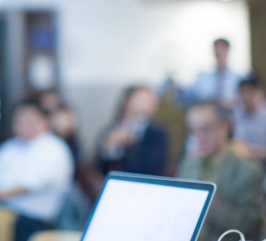 Seyirciler sunumu izliyor. Sahnede kalabalığa konuşma yapan bir sunucu. Yatırımcı sunumu konferansında konuşmacı. Konferans sırasında bulanık sunucu. Seminer fotoğrafı..