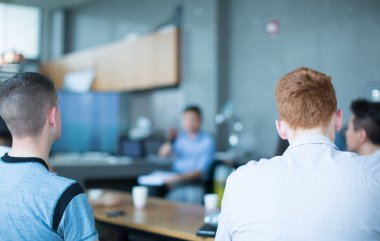 Sözcü bir şirket iş konferansında konuşma yapıyor. Seyirciler sunucu önünde sunucuyla salonda. Şirket yöneticisi iş ve girişimci semineri sırasında konuşma yapıyor. 
