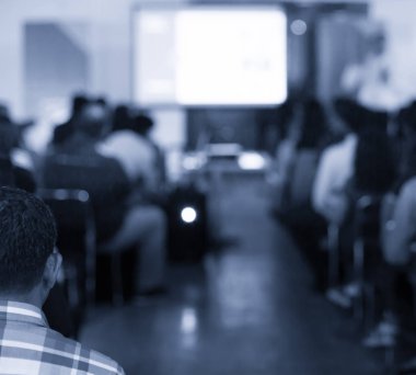 Sözcü bir şirket iş konferansında konuşma yapıyor. Seyirciler sunucu önünde sunucuyla salonda. Şirket yöneticisi iş ve girişimci semineri sırasında konuşma yapıyor.