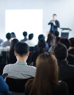 İş konferans odasında halka açık sunumları olan genç bir iş adamı. Konferans salonundaki izleyiciler. Girişimcilik Kulübü