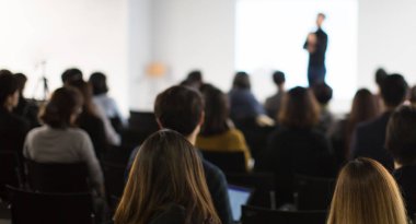 Erkek ve bayan yaratıcı öğrenciler atölyedeki eğitim müdürünün açıklamasını dinliyorlar. Genç profesyonellerle iş semineri düzenleme konusunda yetenekli bir koç. Reklam alanı.