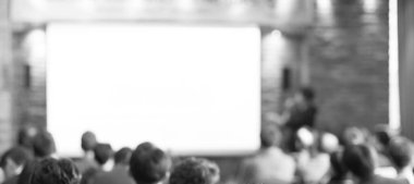 Konferans sunum odasında bulanık odaklanmış seyirci. Konferans salonunda şirket sunumları. Seminer konuşmacısı yeni çalışanlara eğitim veriyor. Forum atölye etkinliğinde sunucu.