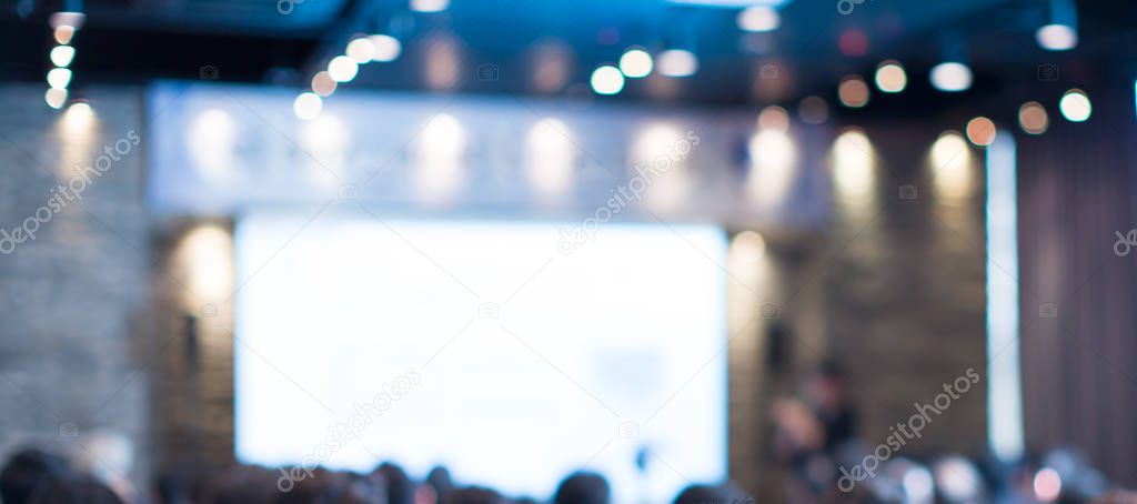 Blurred de-focused audience in conference lecture presentation room. Corporate presentations in conference hall. Seminar speaker giving training to new employees. Presenter in forum workshop event.