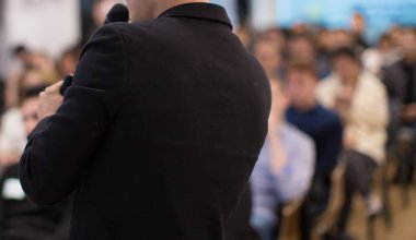 İş koçu. Takım lideri, konferans odasındaki bir iş toplantısında çalışanlara ders veriyor. Bir şirket iş seminerinde konuşmacı konuşma yapıyor. Toplantı salonunda sunucuyla konferans fotoğrafı çekiliyor..