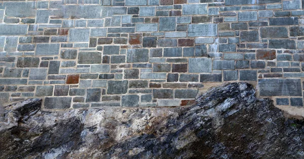 Teil einer Steinmauer, mit Elementen aus Naturgestein als Hintergrund — Stockfoto