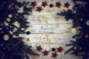 Christmas composition. Frame made of fir tree branches with decoration on rustic wooden background. 