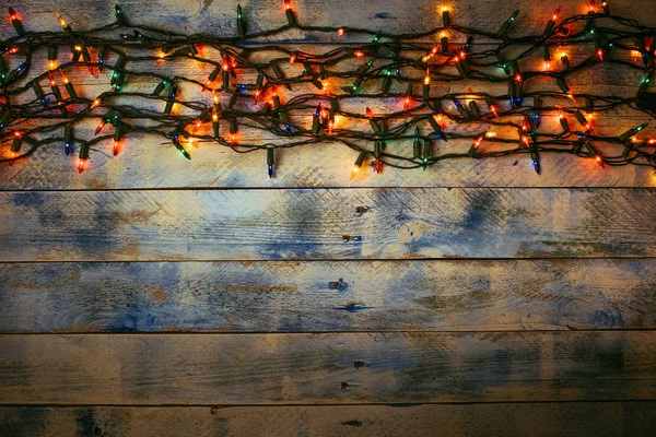 Christmas lights over white and blue painted planks for background. Christmas light decorations on wood texture. — Stockfoto