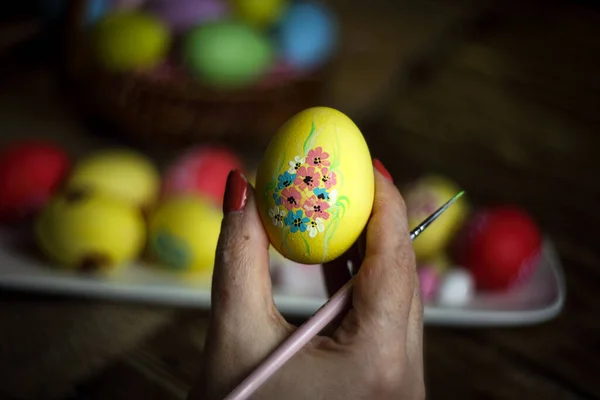 女人的手拿着花纹的蛋 准备复活节 画家画复活节彩蛋 有选择的重点 复制空间 横向方向 — 图库照片