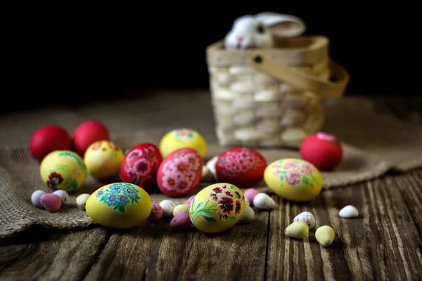 Easter composition on wooden background with rabbit figure. Hand painting Easter eggs. The concept of religious holidays, family traditions. Selective focus. Horizontal orientation. Copy space.