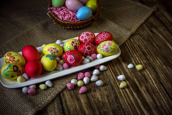 Easter composition on a wooden background. Hand painting Easter eggs. The concept of religious holidays, family traditions. Selective focus. Horizontal orientation. Copy space.