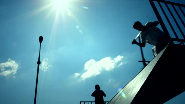 Calci silhouette scooter fare trucchi in città skate park. Rallentatore . — Video Stock