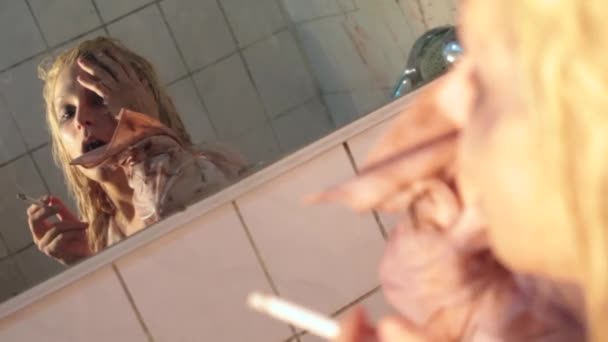 Депресія дівчина дим сигарета торкається її відображення в брудному дзеркалі ванної кімнати — стокове відео