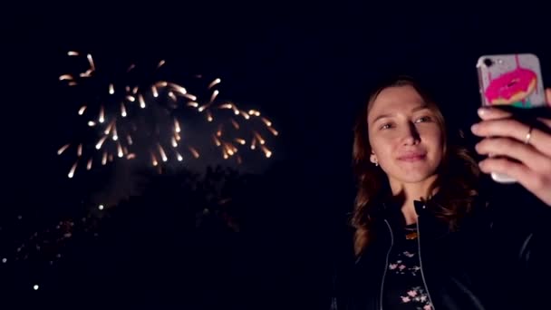 Una mujer viendo los hermosos fuegos artificiales navideños y hacer un video, cámara lenta — Vídeos de Stock