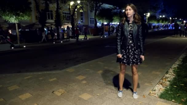 Cansada chica sola esperando a alguien en la calle por la noche. Mirando hacia los lados — Vídeos de Stock