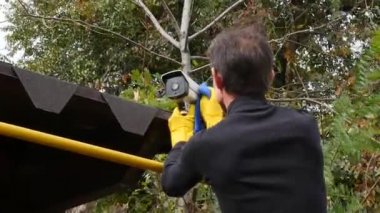 Erkek işçi güvenlik kameralarını temizleyerek bakım yapıyor.