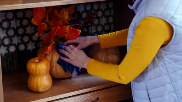 Kobieta myje i wyciera pokrywę dyni z kurzu w szafie jako dekorację — Wideo stockowe