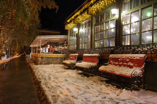 Drei Bänke in der Nähe des irischen Pub, an Weihnachten mit frisch gefallenem Schnee bedeckt Stockbild